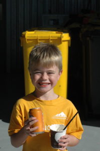 Young child smiling with soda can