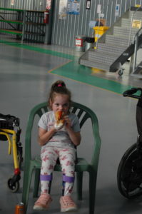 Little girl eating a cupcake in helicopter hangar