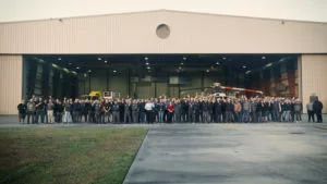 PHI's MRO Services team smiling and posing for a group picture outside of the PHI hangar