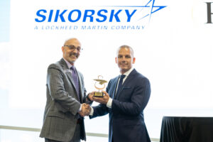 Leon Silva, Sikorsky VP of GCMS, shakes hands with Cory Latiolais, Chief Operating Officer - PHI Aviation Asia-Pacific region, while accepted Sikorsky Winged-S Award