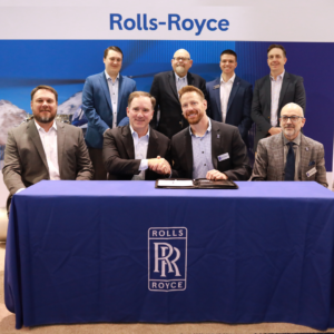Members of the PHI and Rolls-Royce executive leadership teams sit for a signing of the AMC agreement